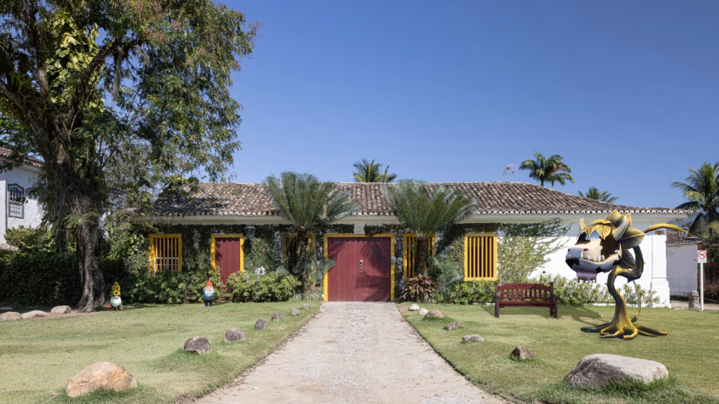 Portas vermelhas, molduras amarelas e a flora natural são a identidade desta casa. Joana França